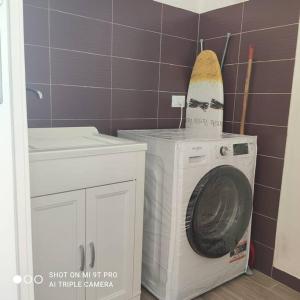 a washing machine with a surfboard on top of it at Casa Cappero in Noto Marina