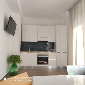 a kitchen with white cabinets and a tv in it at Casa Cappero in Noto Marina
