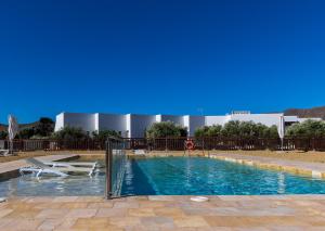 una piscina con una silla y una mesa en Oro y Luz, en Rodalquilar