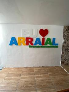 a sign on a wall with the acu armani logo at Paradise Suítes in Arraial do Cabo