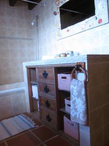 a bathroom with a vanity with a sink and a tub at Golf & Surf Holiday House in Casal da Lagoa Seca