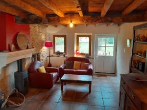 salon z 2 krzesłami i kominkiem w obiekcie Grange rénovée et son jardin dans l'Avant Pays Savoyard w mieście Champagneux +1 zdjęcie