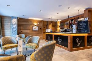 una sala de espera con sillas y un bar en CGH Résidences & Spas White Pearl Lodge, en La Plagne