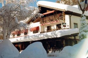 a snow covered building with a balcony in the snow at Albergo Martinet in Vernante