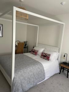 um quarto com uma grande cama branca com almofadas de arco vermelho em The Hideaway em Modbury