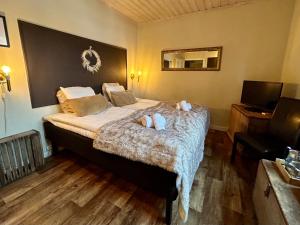 a bedroom with a bed with two towels on it at Kungshaga Hotell in Orsa