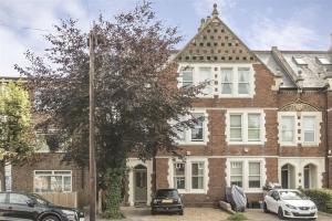 a large brick building with cars parked in front of it at Light and Modern 2BR 1.5BA, newly refurbished! in Raynes Park