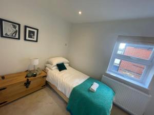 a bedroom with a bed and a window at Light and Modern 2BR 1.5BA, newly refurbished! in Raynes Park