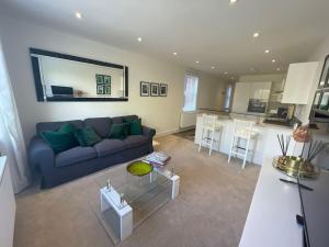 a living room with a blue couch and a kitchen at Light and Modern 2BR 1.5BA, newly refurbished! in Raynes Park