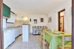 a kitchen and dining room with a green table in a room at Appartamenti Le Querce App. Ginestra in Capoliveri