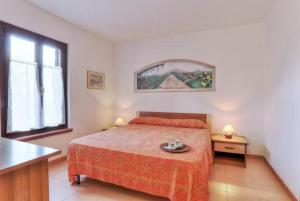 a bedroom with a bed and a table and a window at Appartamenti Le Querce App. Ginestra in Capoliveri