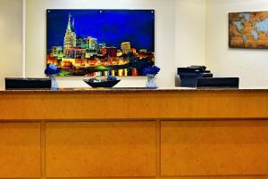 a reception desk with a picture of a city at La Quinta by Wyndham Nashville Airport/Opryland in Nashville