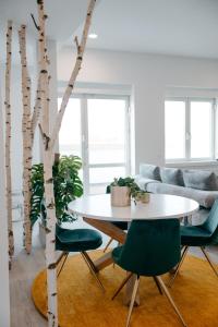 a table and chairs in a living room with a tree at The Blasky in Frankfurt/Main