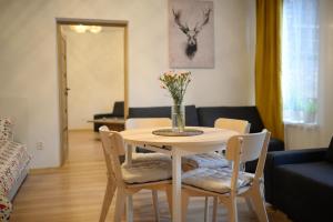 een tafel met stoelen en een vaas met bloemen erop bij Wood Apartment z Konsola X-Box in Katowice