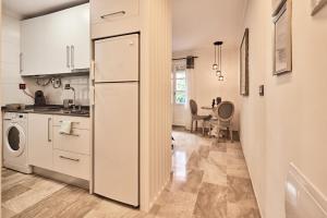 kuchnia z białymi szafkami i lodówką w obiekcie Little Sopranis Little Apartments w Kadyksie