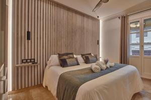 a bedroom with a large bed with towels on it at Little Sopranis Little Apartments in Cádiz