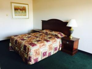 a bedroom with a bed and a table with a lamp at Summer Wind Budget Motel in Newport