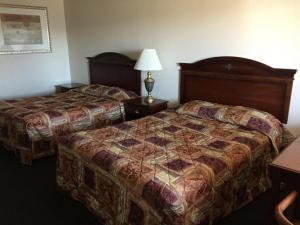 a hotel room with two beds and a lamp at Summer Wind Budget Motel in Newport