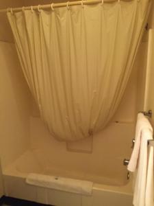 uma casa de banho com uma cortina de chuveiro e uma banheira em Summer Wind Budget Motel em Newport