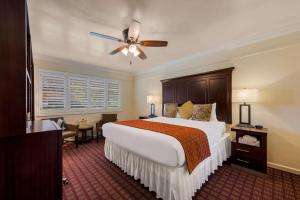 a bedroom with a large bed and a ceiling fan at Clarion Collection Carmel Oaks Inn in Carmel