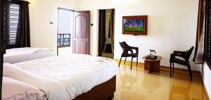 a bedroom with two beds and a table and chairs at Rosan Heritage - A Beach Villa in Kanyakumari