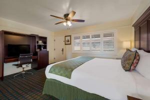 カーメルにあるClarion Collection Carmel Oaks Innのベッド1台、天井ファンが備わる客室です。