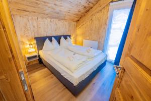 een slaapkamer met een bed in een houten kamer bij Hillside Chalet Kreischberg in Sankt Lorenzen ob Murau