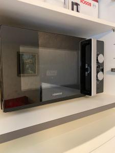 a microwave oven on a shelf in a store at Lovely Studio in Kallio in Helsinki