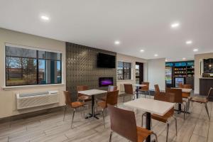 a restaurant with tables and chairs and a tv at Clarion Pointe Harrodsburg-Danville in Harrodsburg