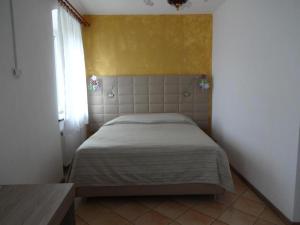 a bedroom with a bed with a yellow wall at Fedrig Rooms with bathroom & Hostel Rooms in Kobarid