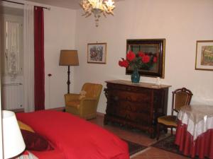 1 dormitorio con cama roja, mesa y sillas en B&B Fiordaliso, en Florencia