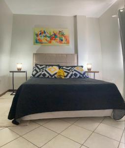 sypialnia z dużym czarnym łóżkiem z 2 świecami w obiekcie Hermoso departamento en Bombas con vista al mar w mieście Bombinhas
