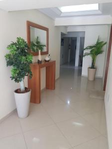 a hallway with two potted plants in a building at Hermoso departamento en Bombas con vista al mar in Bombinhas
