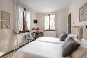 a bedroom with two beds and a desk and windows at Rimon Place-Kosher in Venice