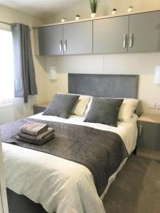 a bedroom with a large bed with grey cabinets at Cumbria Reach in Longtown