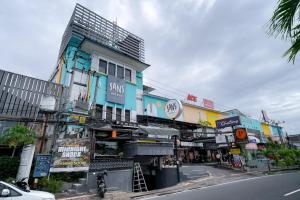 a city street with a building with many signs at Sans Sunset Point Seminyak in Seminyak