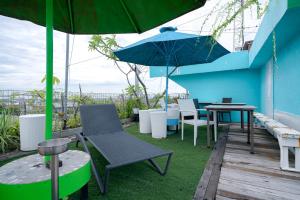 a patio with a table and chairs and an umbrella at Sans Sunset Point Seminyak in Seminyak