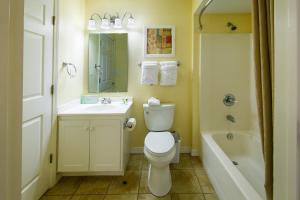 a bathroom with a toilet and a sink and a tub at Holiday Inn Club Vacations Galveston Seaside Resort, an IHG Hotel in Galveston