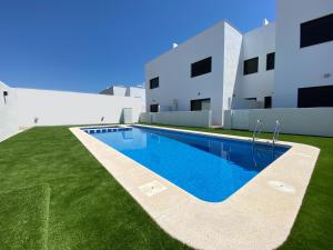a swimming pool in front of a white building at Villamar 15B - Ático con solárium cerca de las salinas in San Pedro del Pinatar