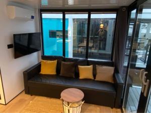 um sofá preto com almofadas amarelas num quarto com uma janela em Ringö Resort em Gotemburgo