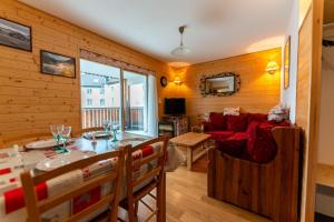 jadalnia i salon z czerwoną kanapą w obiekcie Warm 29m with balcony and lake view w mieście Gérardmer