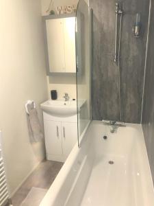 a bathroom with a tub and a sink and a shower at Cumbria Reach in Longtown +14 photos