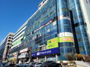 un edificio alto con coches estacionados frente a él en Canberra Town 439-3 en Changwon