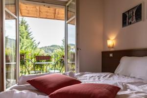 sypialnia z łóżkiem i dużym oknem w obiekcie Hotel Cortese w mieście Armeno