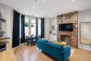 a living room with a blue couch and a brick fireplace at Stylish modern apartment near the city centre with nearby off-road parking in Cardiff