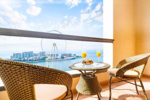 a balcony with two chairs and a table with two drinks at LUX The JBR BlueWaters View Suite 2 in Dubai