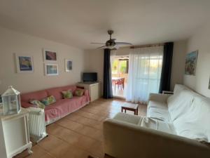 ein Wohnzimmer mit einem Sofa und einem TV in der Unterkunft Apartamentos Arcos Calabardina in Calabardina