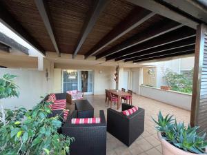 eine Außenterrasse mit Sofas und einem Tisch in der Unterkunft Apartamentos Arcos Calabardina in Calabardina