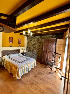 1 dormitorio con 1 cama con paredes amarillas y suelo de madera en Apartamentos Turisticos Paseo de la Alameda, en Villaviciosa