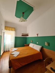 サン・ジョヴァンニ・ロトンドにあるB&B Santa Luciaの緑の壁のベッドルーム1室(大型ベッド1台付)